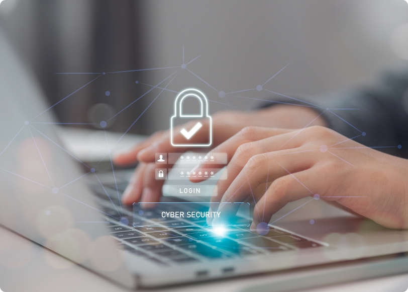 Image of hands typing on a laptop with cyber security graphic overlaid