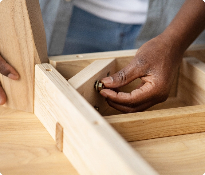 Image of hands fixing the underside of a table.