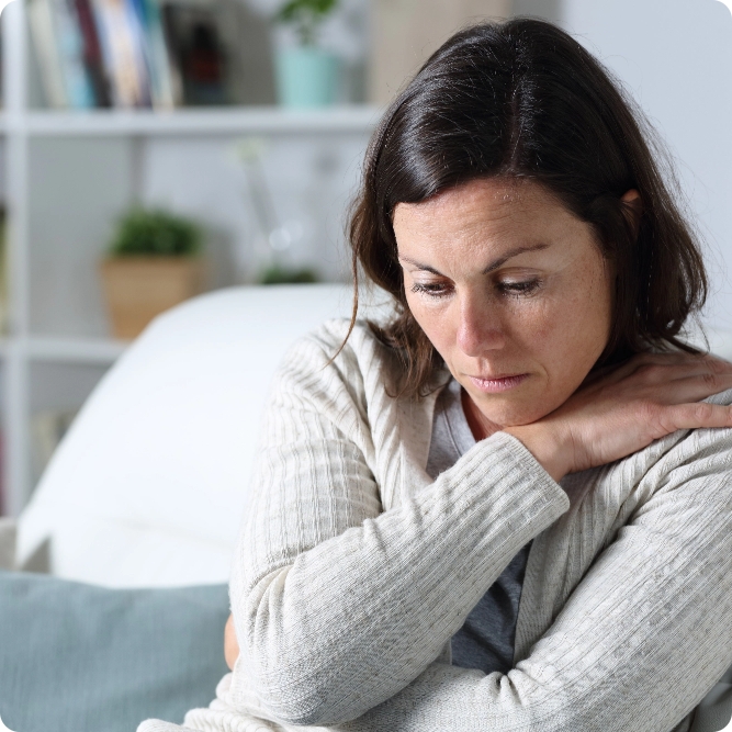 Woman looking distressed, with her arms crossed across her chest.